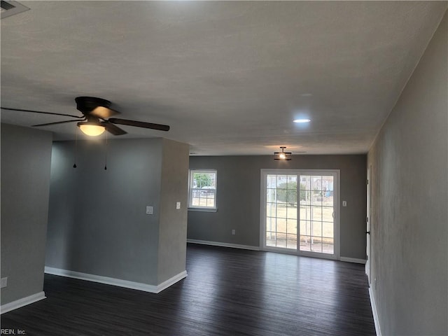 unfurnished room featuring baseboards and dark wood-style flooring