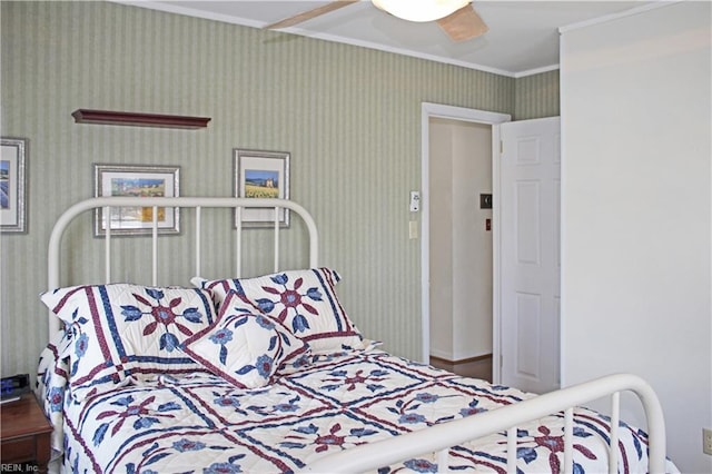 bedroom with wallpapered walls, a ceiling fan, and ornamental molding