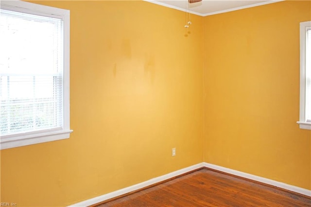 spare room featuring ceiling fan, baseboards, dark wood-type flooring, and ornamental molding