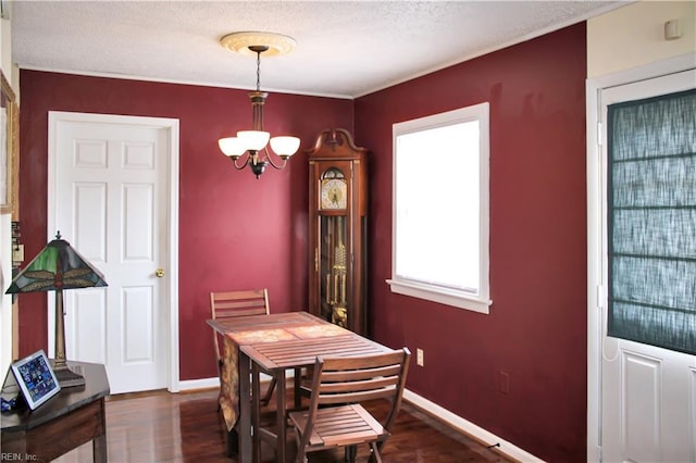 dining room with baseboards, dark wood-type flooring, and a chandelier