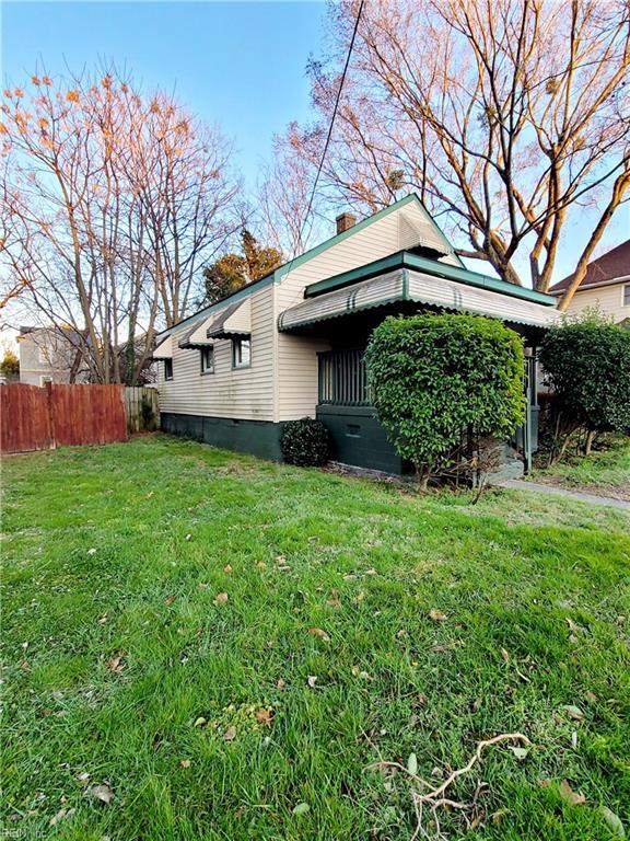 view of side of home featuring a yard, crawl space, fence, and a chimney