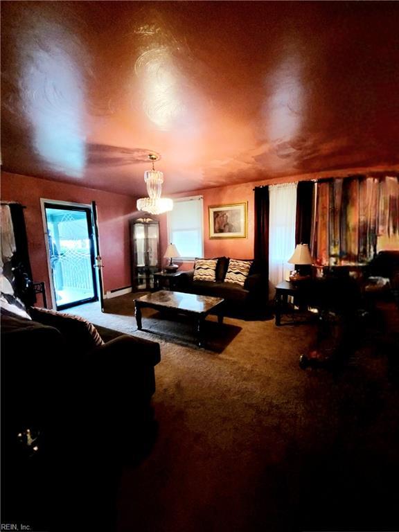 carpeted home theater room featuring a chandelier and a wealth of natural light