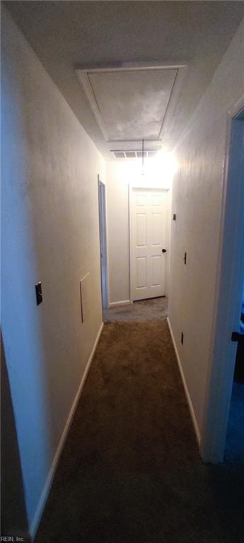 corridor with carpet floors, attic access, and baseboards