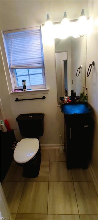 bathroom featuring baseboards, vanity, and toilet