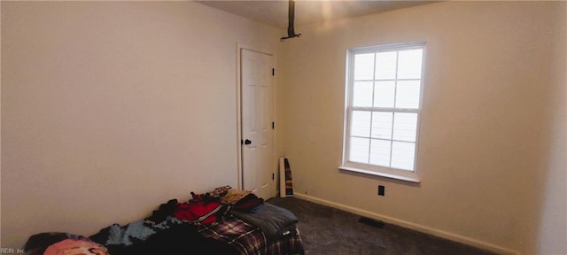 bedroom featuring multiple windows, baseboards, and dark colored carpet