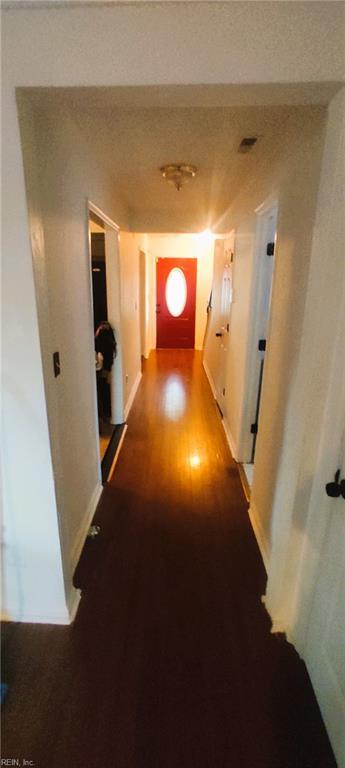 hallway with wood finished floors and baseboards