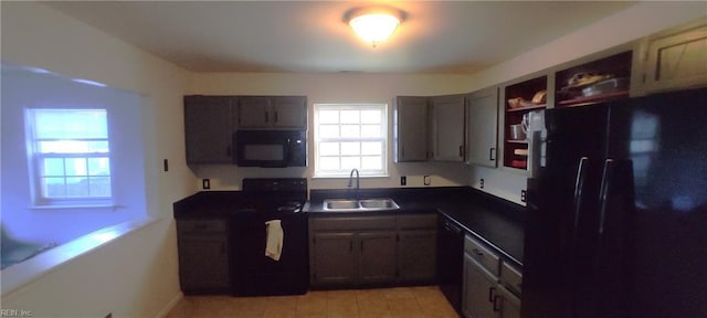 kitchen with dark countertops, black appliances, open shelves, and a sink