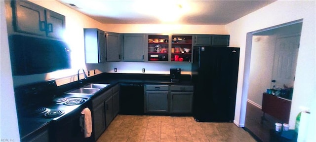 kitchen with dark countertops, a sink, black appliances, and open shelves