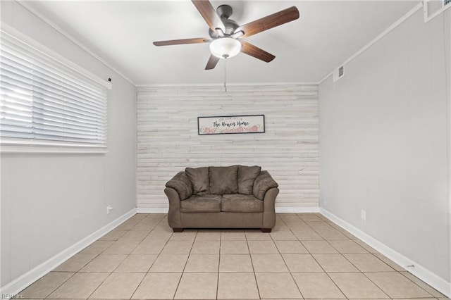 sitting room with a ceiling fan, visible vents, crown molding, and light tile patterned flooring