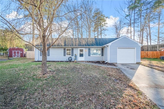 ranch-style home featuring an attached garage, fence, concrete driveway, a shed, and a front yard