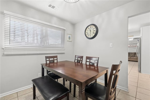 dining area with light tile patterned floors, baseboards, and visible vents