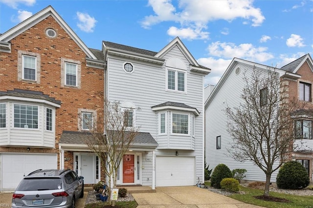 townhome / multi-family property featuring a garage, concrete driveway, and brick siding