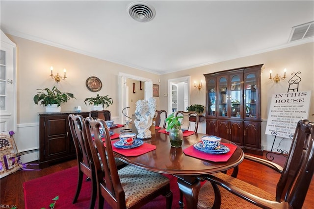 dining room with visible vents, baseboard heating, dark wood-style floors, and ornamental molding