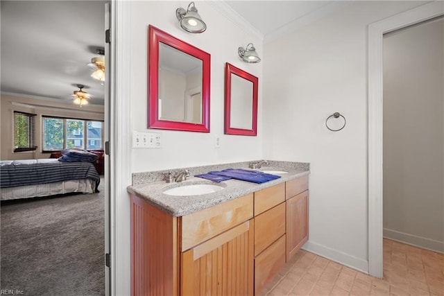 ensuite bathroom with connected bathroom, crown molding, baseboards, double vanity, and a sink