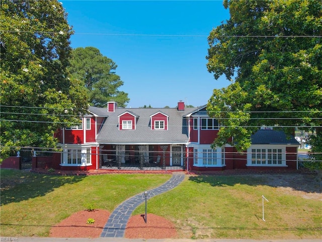 view of front of property with a chimney, a front yard, and fence