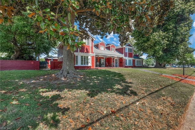 view of front of home with a front yard and fence