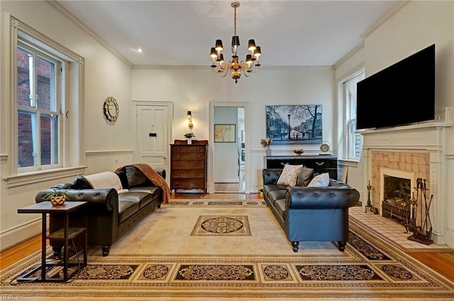 living area with ornamental molding, a tiled fireplace, wood finished floors, and a wealth of natural light