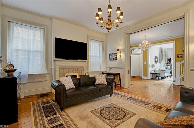 living room featuring crown molding, a notable chandelier, and wood finished floors