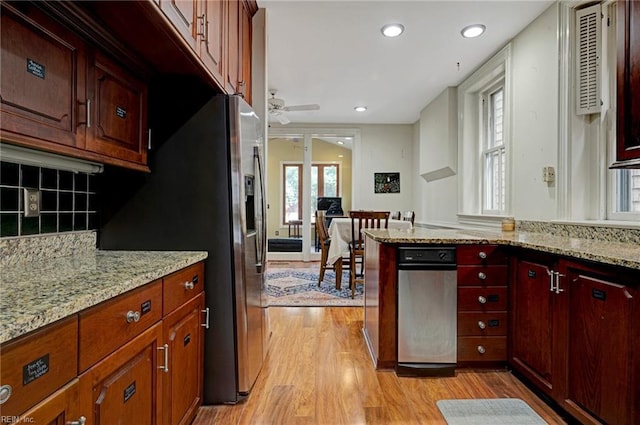 kitchen featuring stainless steel refrigerator with ice dispenser, light wood-type flooring, and light stone counters