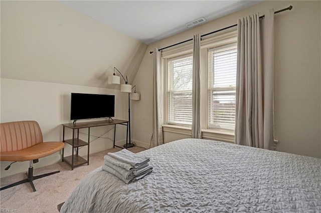 carpeted bedroom featuring baseboards, visible vents, and vaulted ceiling