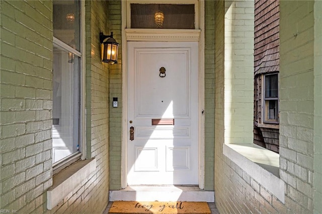 entrance to property featuring brick siding