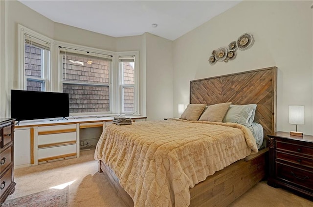 bedroom with light carpet and built in desk