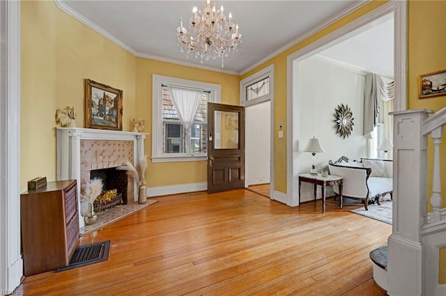 sitting room featuring ornamental molding, visible vents, a fireplace with flush hearth, and hardwood / wood-style flooring