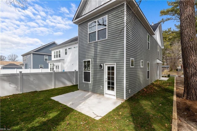 rear view of house featuring a patio, a lawn, and fence