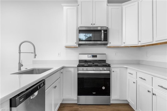 kitchen with a sink, stainless steel appliances, white cabinets, and light countertops