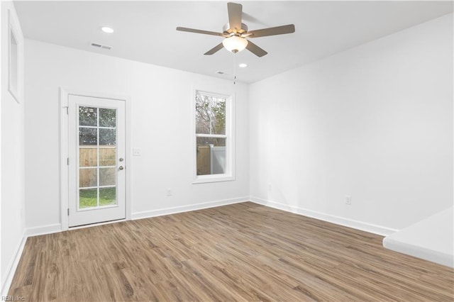 empty room featuring recessed lighting, visible vents, baseboards, and wood finished floors