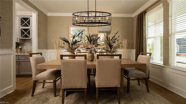 dining room with ornamental molding, wainscoting, and wallpapered walls