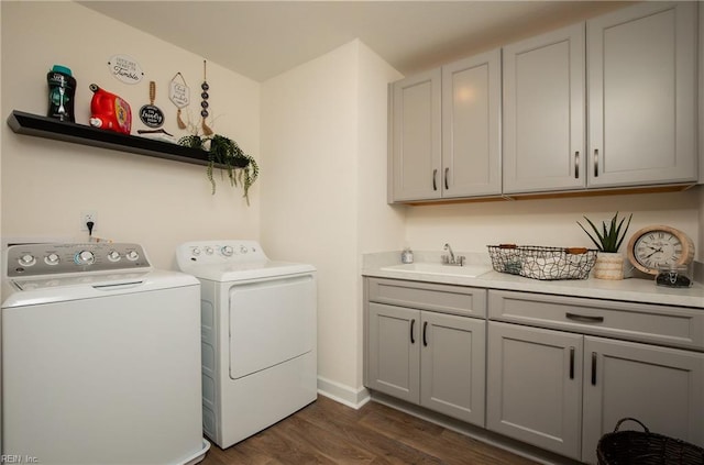 laundry room with cabinet space, dark wood-style floors, a sink, and washing machine and clothes dryer