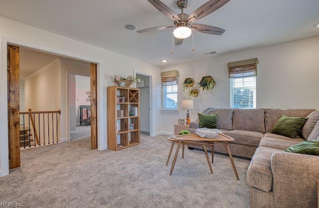 living area with light carpet, ceiling fan, and baseboards