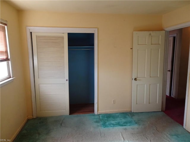 unfurnished bedroom featuring carpet floors, a closet, and baseboards