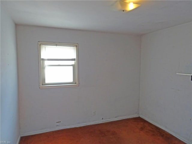 carpeted spare room featuring baseboards