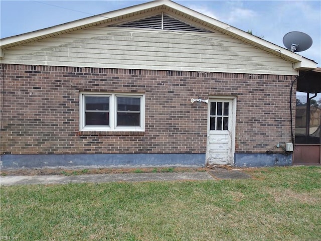 view of home's exterior with brick siding and a yard