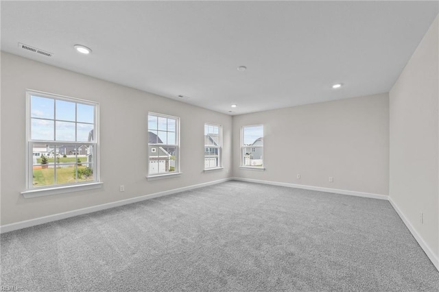 spare room featuring carpet floors, baseboards, visible vents, and recessed lighting