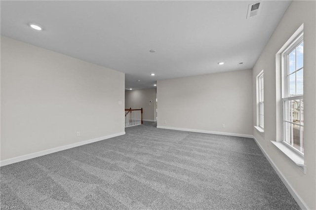 carpeted spare room featuring recessed lighting, visible vents, and baseboards