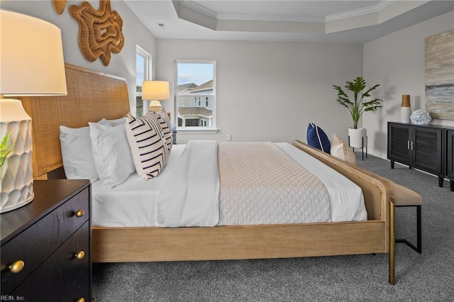 bedroom with carpet floors, a tray ceiling, and crown molding