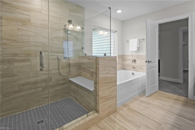 bathroom with a shower stall and a bath