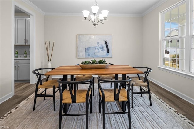 dining area featuring baseboards, crown molding, wood finished floors, and an inviting chandelier