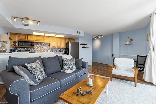 living area featuring light wood-type flooring and visible vents