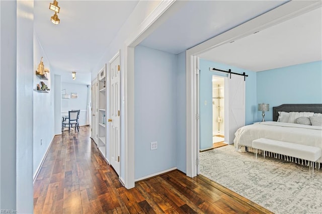 hallway featuring a barn door and dark wood-type flooring