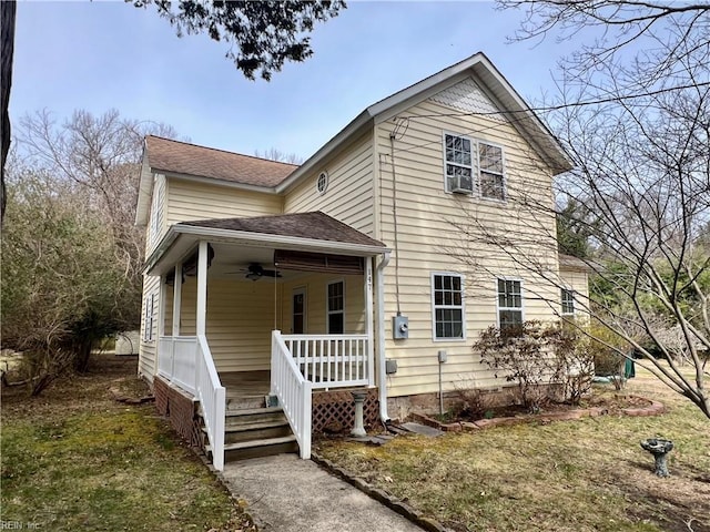 view of front facade with a porch, a shingled roof, and a ceiling fan