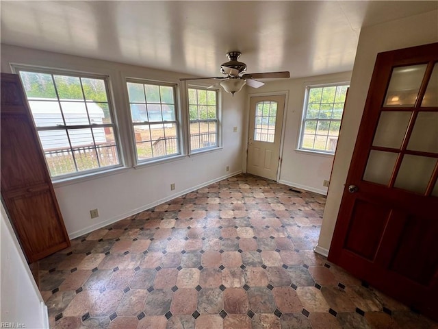 interior space with a ceiling fan and baseboards