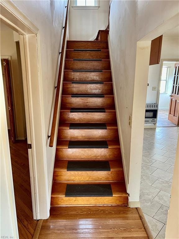 staircase with a wealth of natural light and wood finished floors