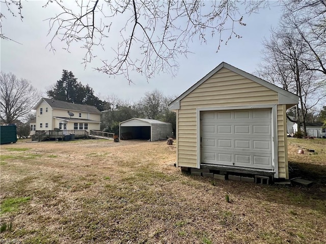 detached garage featuring driveway and a carport