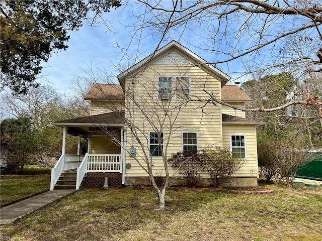 view of front of house featuring a shingled roof, a porch, and a front yard