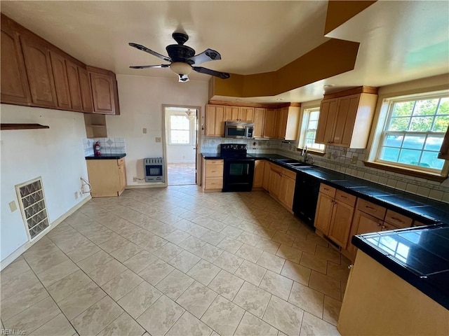 kitchen featuring black appliances, decorative backsplash, visible vents, and heating unit