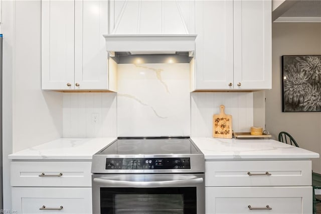 kitchen with premium range hood, light stone counters, backsplash, and stainless steel range with electric cooktop